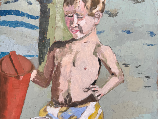 Niño en playa bajo sombra
